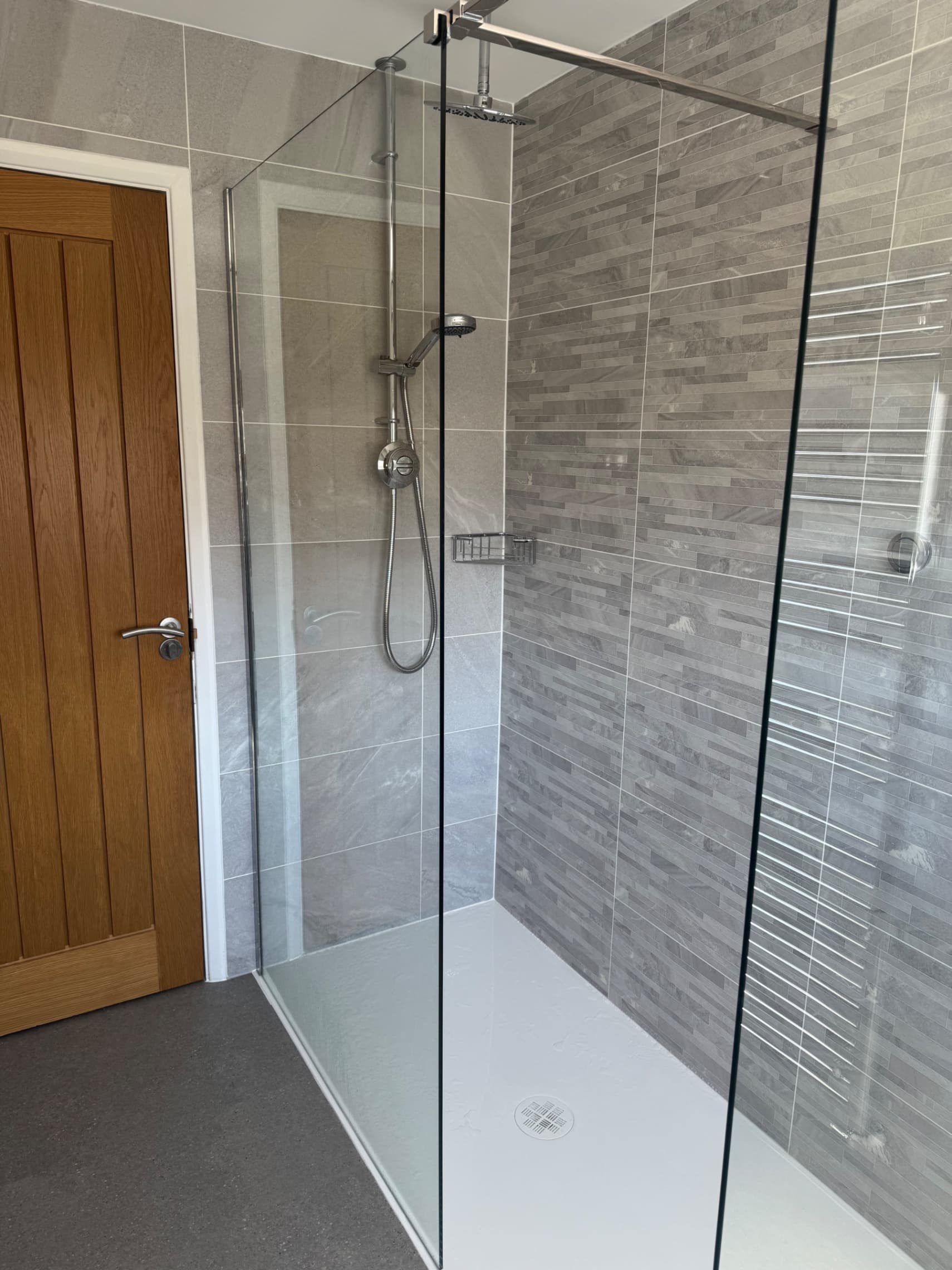 We've finished fitting this bathroom in Wokingham. It includes a spacious walk-in shower, grey stone-effect tiling, and a frameless glass screen that really opens up the space. The shower is fully fitted with a rainfall head and handheld option.