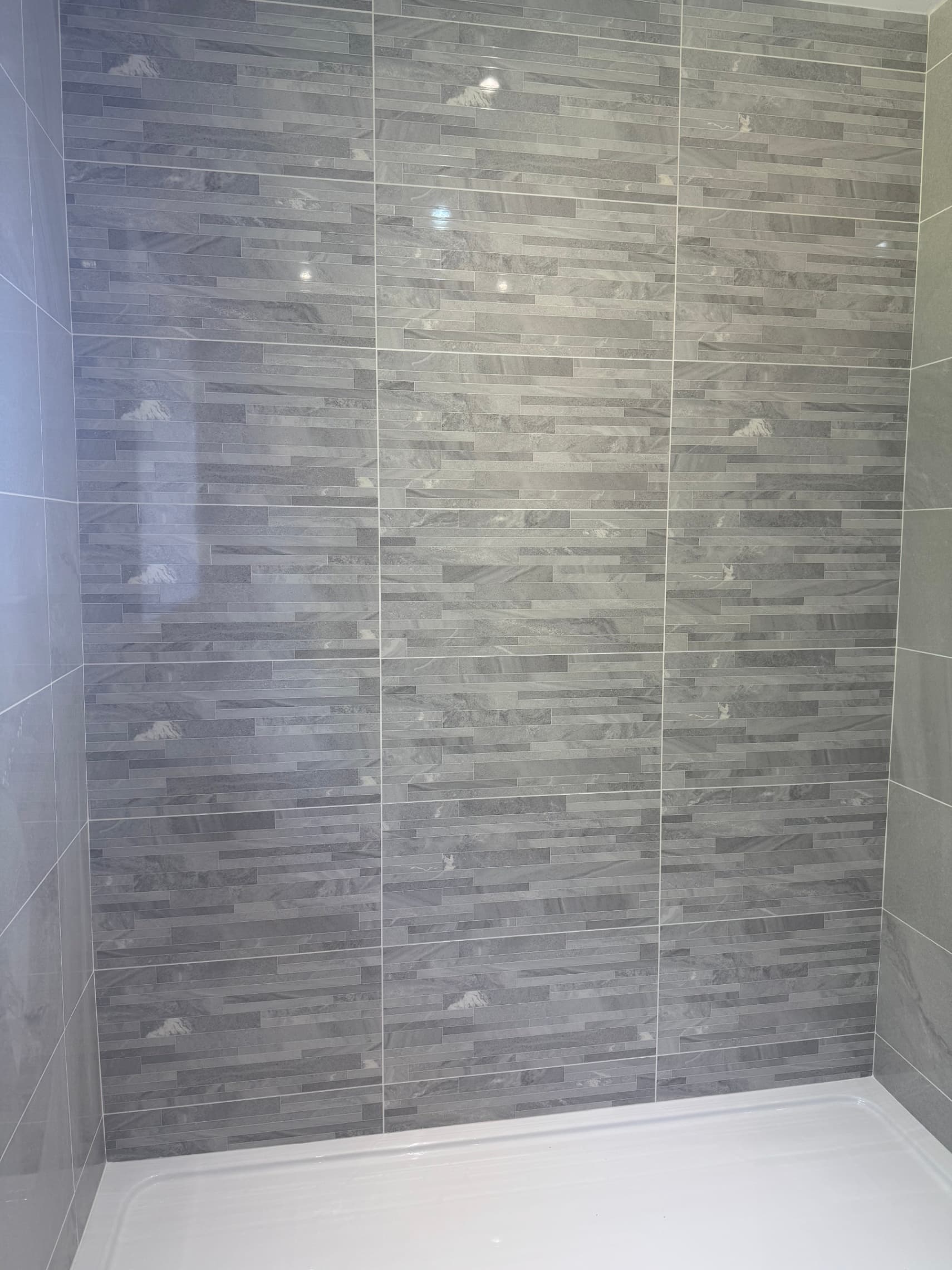 We've just finished tiling this shower enclosure with a nice polished slate-effect finish – the random brick pattern gives it a modern look while the large format tiles keep it clean and easy to maintain.